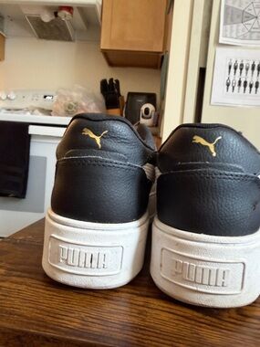Puma Black Low-Top Sneakers with White Sole and Gold Accent